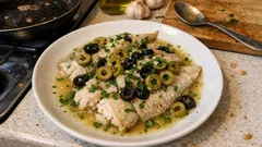 Filetti di platessa alle olive in padella: pronti in pochi minuti con vino bianco